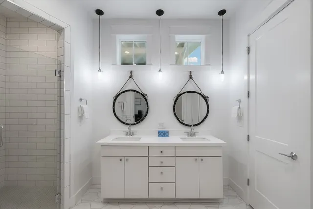 a bathroom with a double vanity sink mirror and shower
