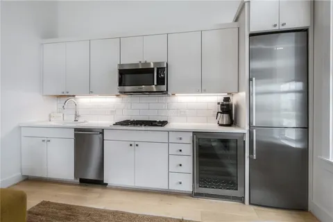 a kitchen with white cabinets stainless steel appliances and sink