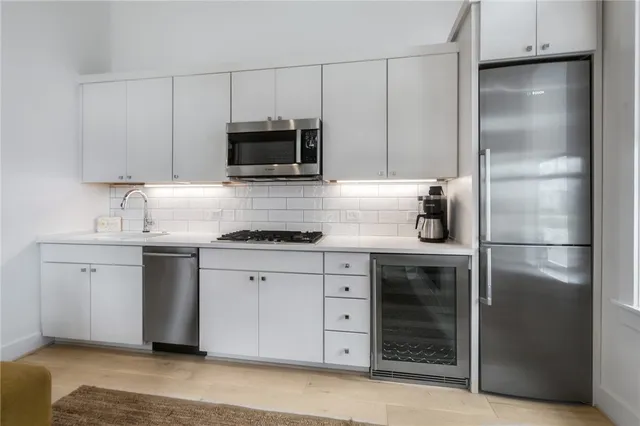 a kitchen with white cabinets stainless steel appliances and sink
