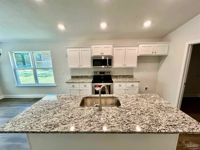 a spacious bedroom with a bed and a chandelier