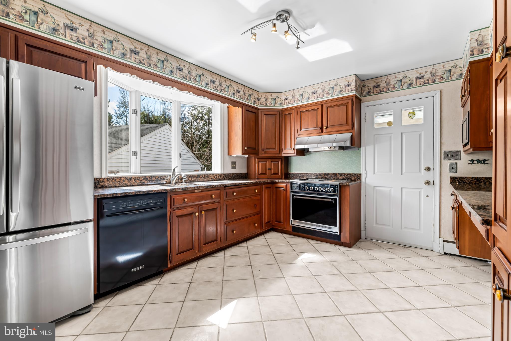 1607 Ruxton Road Towson, MD 21204 - Photo 13 of 46 a kitchen with granite countertop a refrigerator cabinets and wooden floor