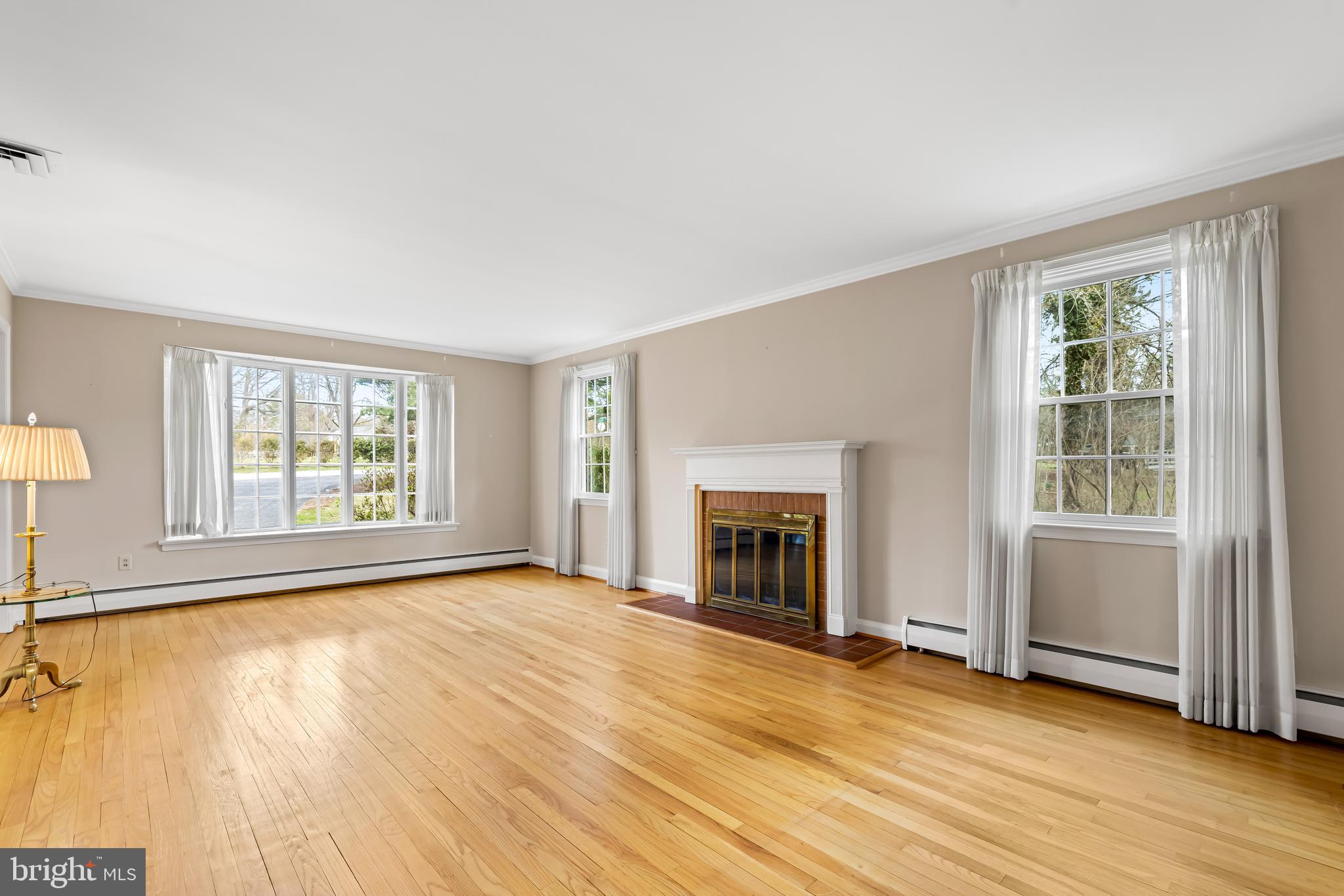 1607 Ruxton Road Towson, MD 21204 - Photo 9 of 46 wooden floor fireplace and windows in an empty room
