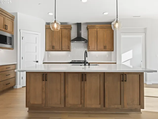 a kitchen with stainless steel appliances granite countertop a sink a stove and a wooden floors