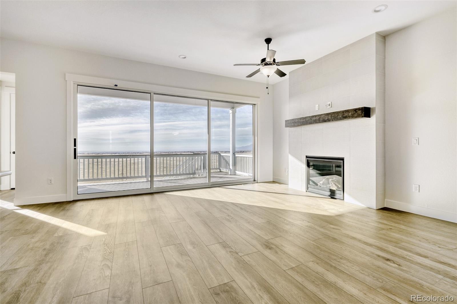 9659 Owl Perch Loop Colorado Springs, CO 80908 - Photo 6 of 28 a view of an empty room with wooden floor fireplace and a window