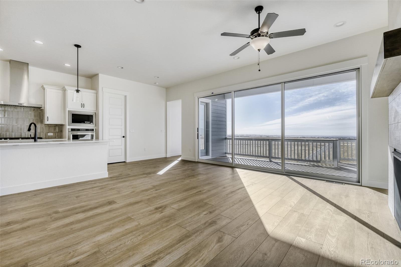 9659 Owl Perch Loop Colorado Springs, CO 80908 - Photo 9 of 28 a view of a kitchen with a stove and wooden floor
