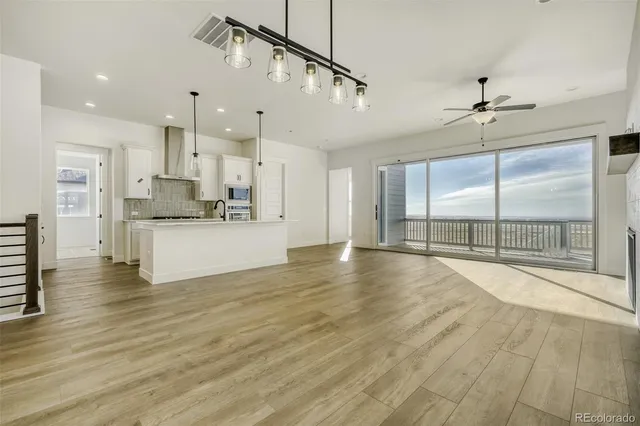 a view of a kitchen with kitchen island a sink stainless steel appliances and cabinets