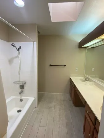 a bathroom with a tub sink and mirror