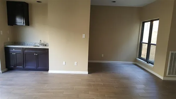 an empty room with windows and cabinet