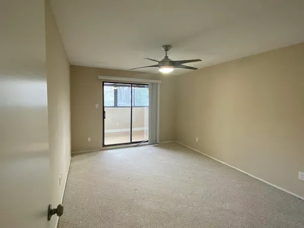 an empty room with a ceiling fan and a window