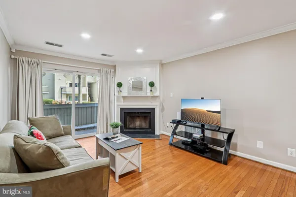 a living room with furniture a fireplace and a floor to ceiling window