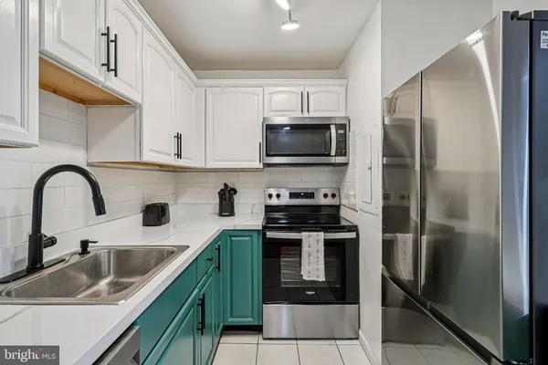 a kitchen with stainless steel appliances granite countertop a sink a stove and refrigerator