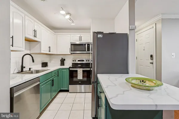 a kitchen with stainless steel appliances granite countertop a sink a stove a refrigerator a microwave oven with a dining table and chairs