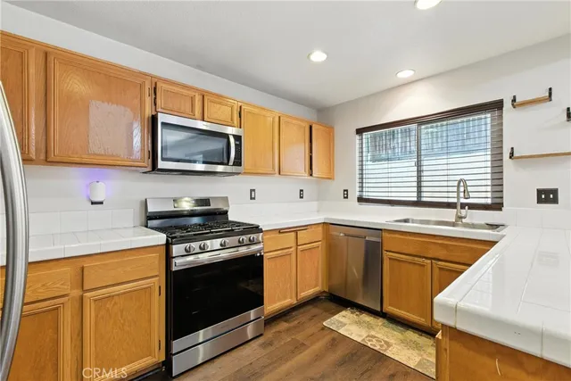 a kitchen with stainless steel appliances granite countertop wooden cabinets stove top oven and sink