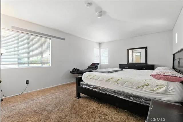 a spacious bedroom with a bed and window