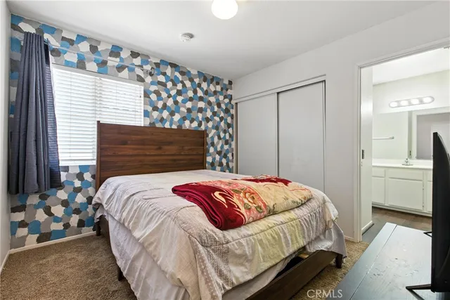 a bedroom with a bed and dresser with mirror