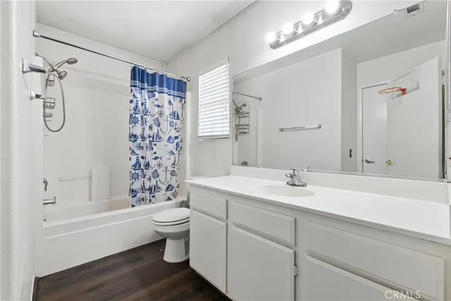 a bathroom with a granite countertop sink a toilet and shower