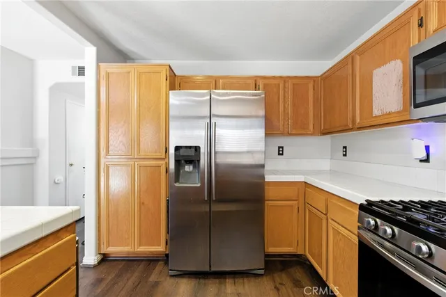a kitchen with stainless steel appliances granite countertop a refrigerator and a stove