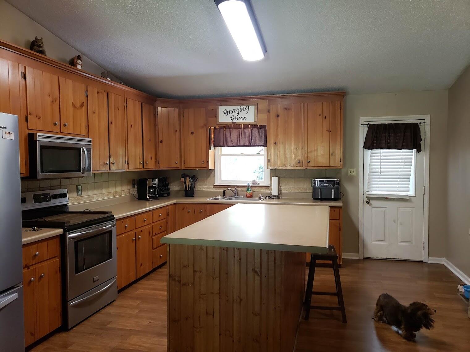 2040 Dugspur Road Callaway, VA 24067 - Photo 3 of 15 a kitchen with kitchen island granite countertop wooden cabinets a stove a microwave a sink and dishwasher with wooden floor