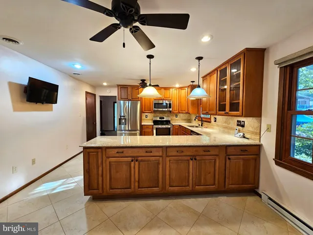 a large kitchen with a sink and a refrigerator