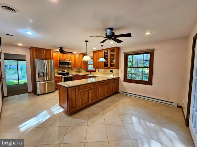 a kitchen with stainless steel appliances granite countertop a stove a sink and a refrigerator with wooden floor