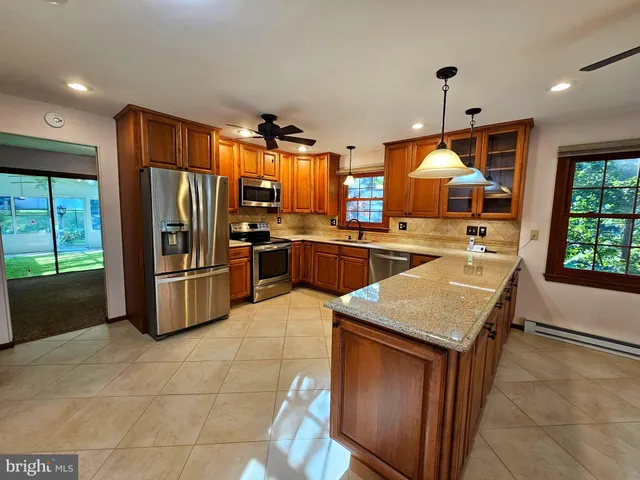 a kitchen with stainless steel appliances granite countertop a refrigerator a sink a stove and island