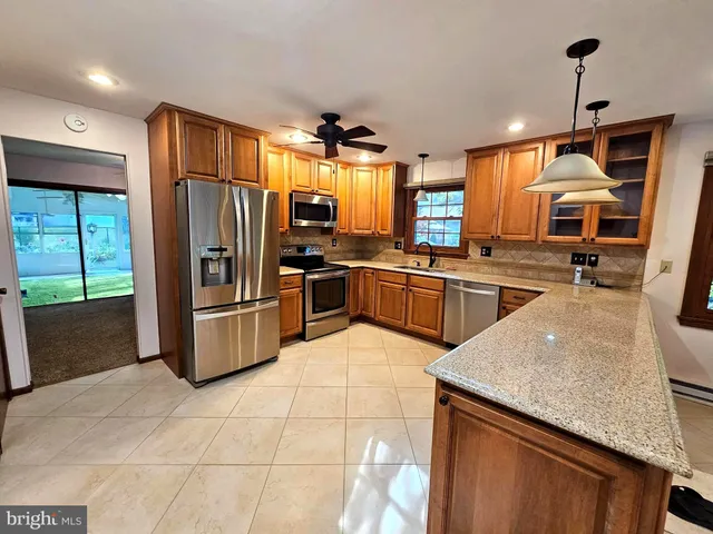 a kitchen with stainless steel appliances granite countertop a sink a stove and a refrigerator