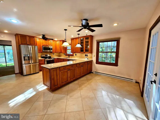 a kitchen with stainless steel appliances granite countertop a stove a sink and a refrigerator