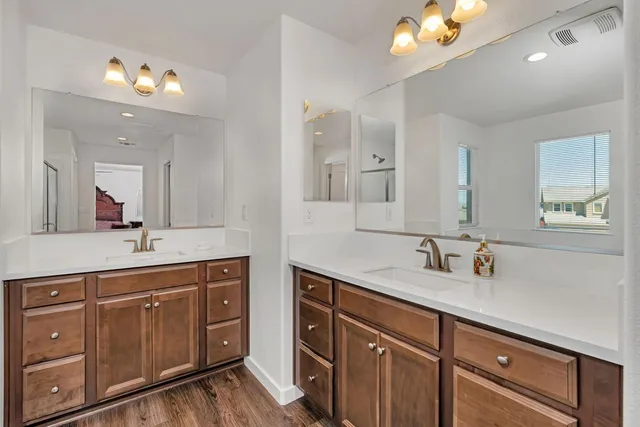a bedroom with a bed and a potted plant on the dresser