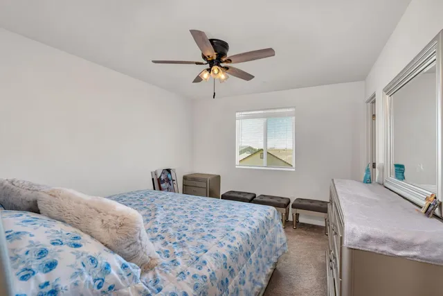 a bed sitting in a bedroom next to a window with a chandelier