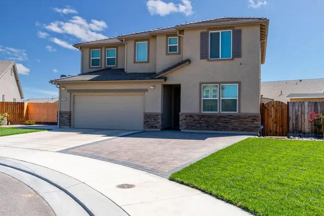 a front view of a house with a yard and a garage