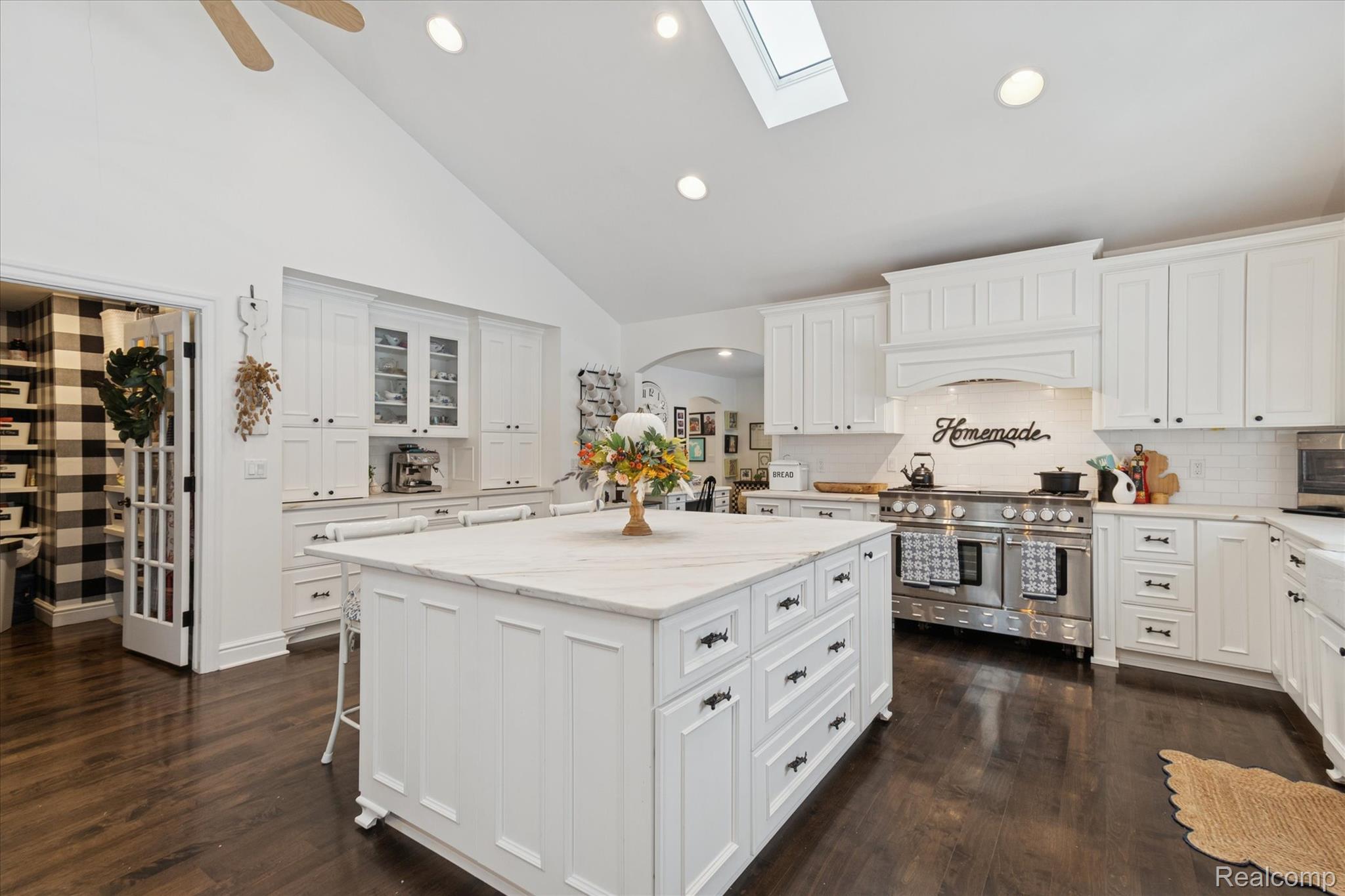 187 Darwin Road Pinckney, MI 48169 - Photo 15 of 71 Kitchen featuring high vaulted ceiling, a skylight, a center island, and abundance of cabinetry