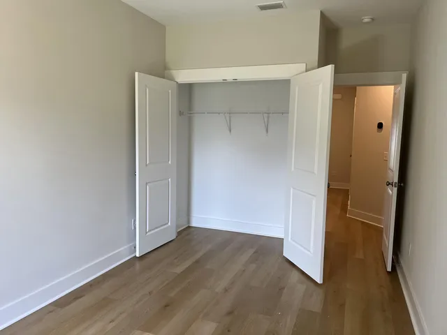 an empty room with wooden floor and entrance