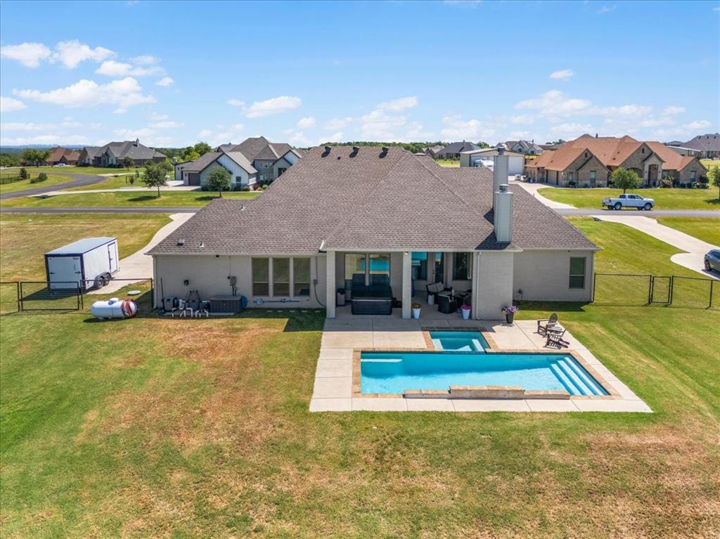 329 Palo Alto Drive Springtown, TX 76082 - Photo 31 of 34 Rear exterior featuring a swimming pool with integrated spa and additional hot tub under the patio.