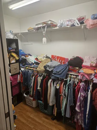 a view of walk in closet with clothes and shoes
