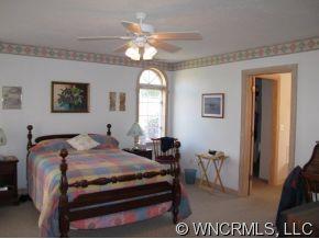 2301 North River Road Tryon, NC 28782 - Photo 6 of 12 a bedroom with a bed and a chandelier
