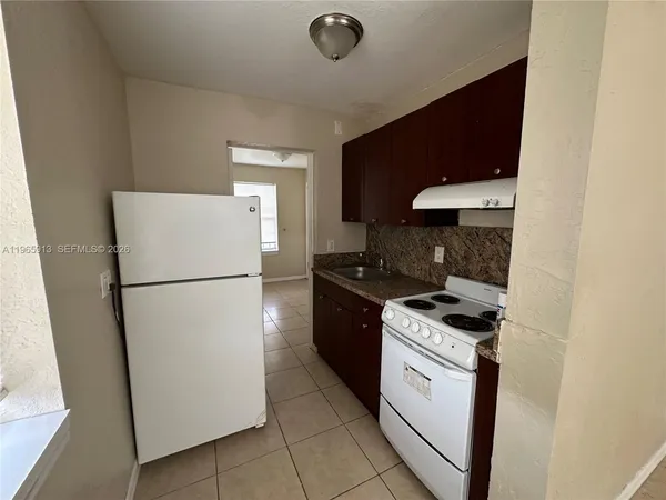 a kitchen with a stove top oven and refrigerator