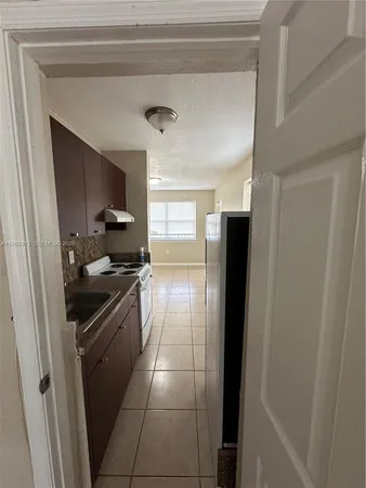 a kitchen with granite countertop a refrigerator and a stove