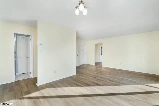 a view of empty room with wooden floor and ceiling fan