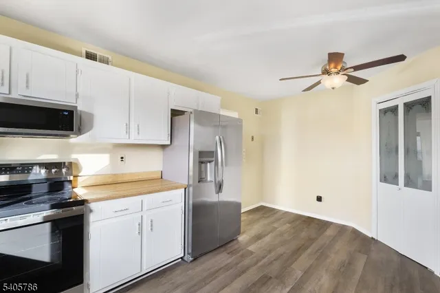 a kitchen with a refrigerator a stove a microwave and cabinets