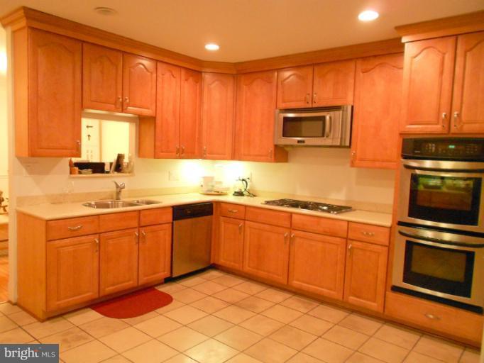 1260 Columbia Road Northwest Washington, DC 20009 - Photo 5 of 19 a kitchen with granite countertop stainless steel appliances a stove sink and microwave