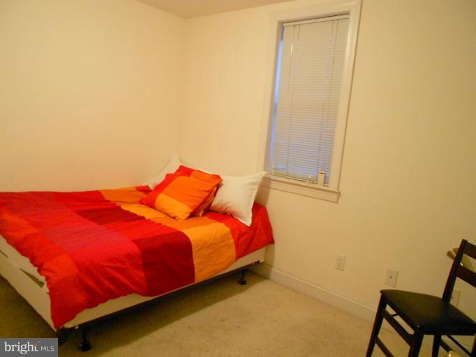 1260 Columbia Road Northwest Washington, DC 20009 - Photo 7 of 19 a bed sitting in a bedroom next to a window