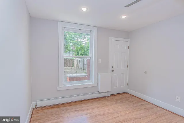 a view of an empty room with wooden floor