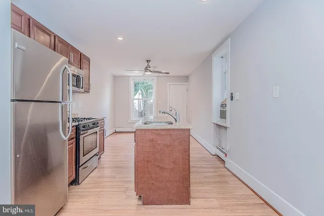 a kitchen with stainless steel appliances granite countertop a refrigerator stove and sink