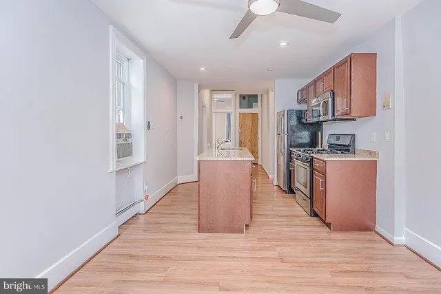 a kitchen with stainless steel appliances granite countertop a refrigerator a stove top oven a sink and dishwasher