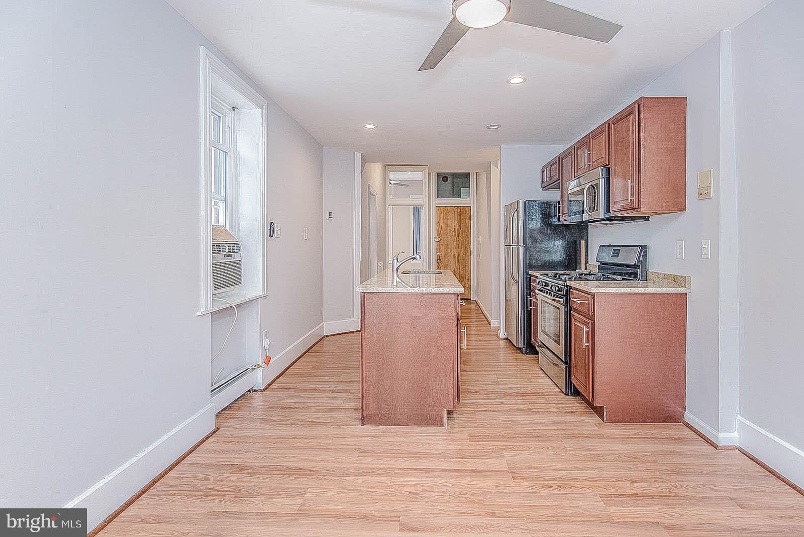 2022 Ogden Street Philadelphia, PA 19130 - Photo 7 of 44 a kitchen with stainless steel appliances granite countertop a refrigerator a stove top oven a sink dishwasher and wooden cabinets