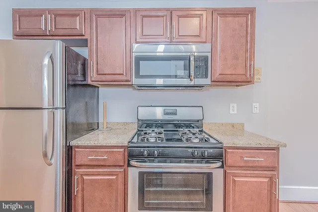 a kitchen with a sink granite top and a stove