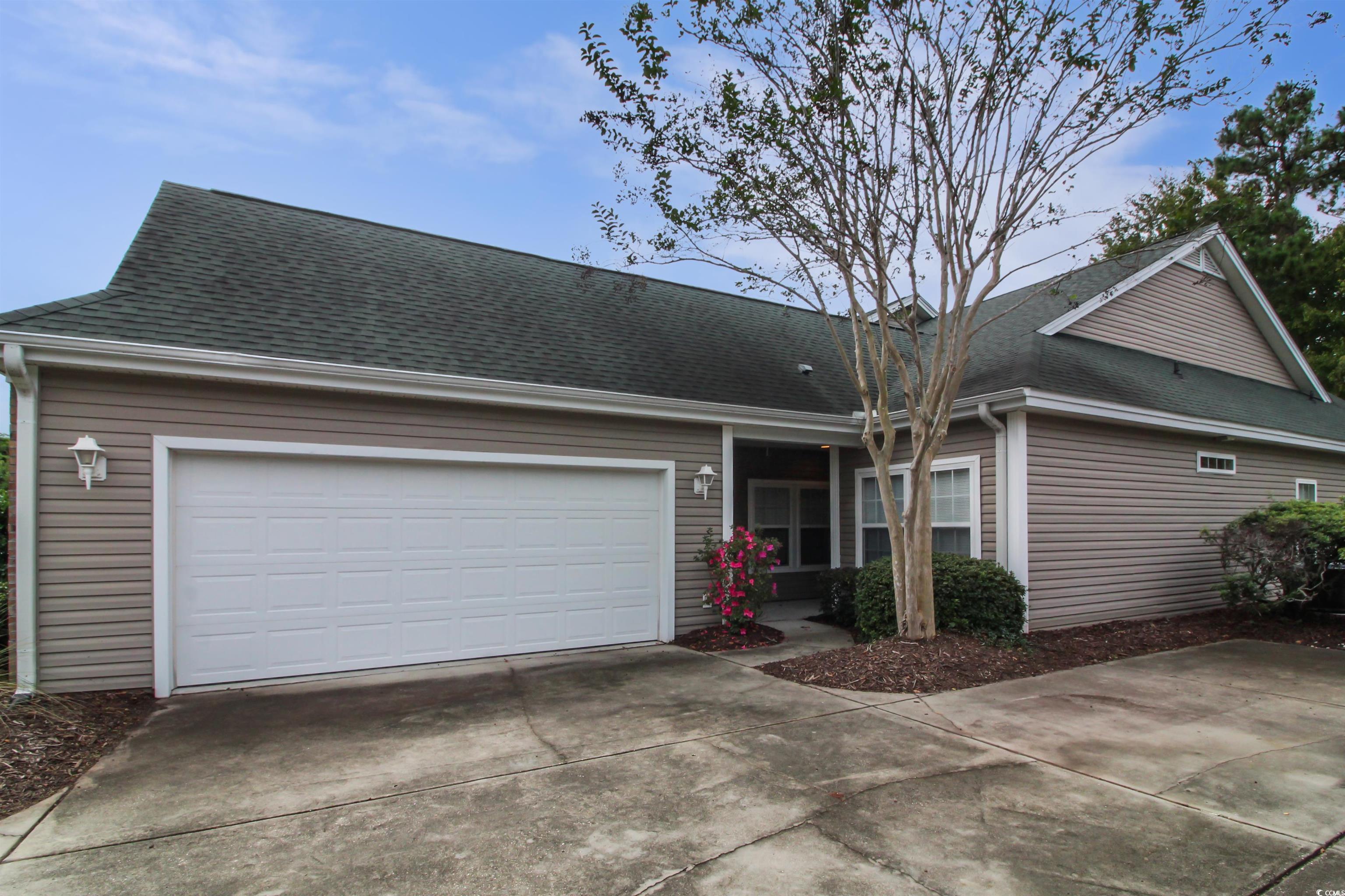 Ranch-style home with a shingled roof, concrete driveway, and an attached garage