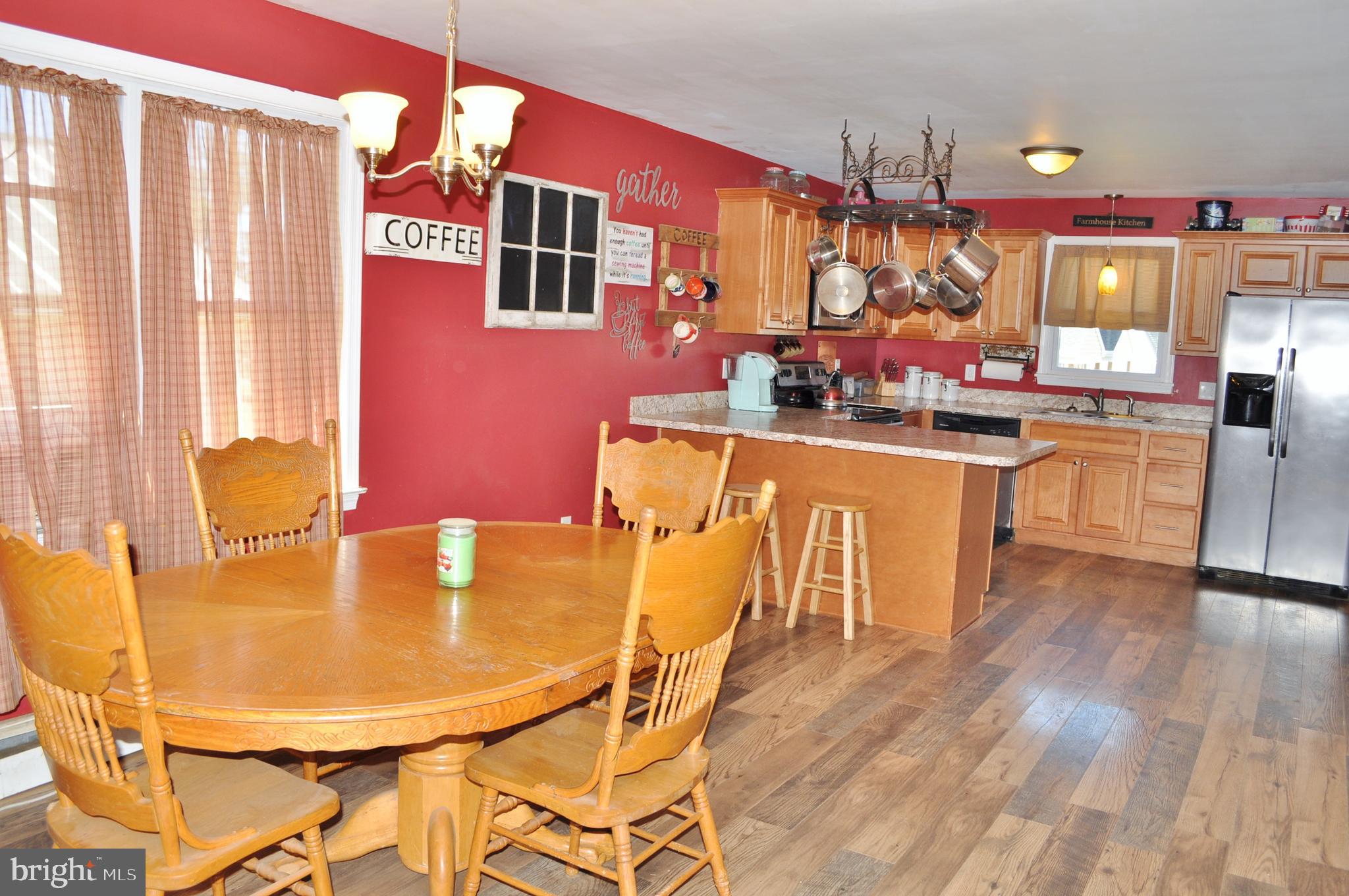 1976 Stoverstown Road Spring Grove, PA 17362 - Photo 13 of 66 a kitchen with stainless steel appliances granite countertop a kitchen island a stove a dining table and chairs with wooden floor