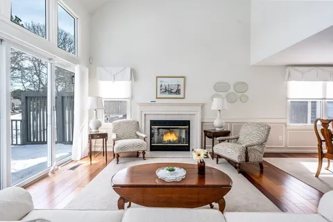 a living room with furniture a fireplace and a large window