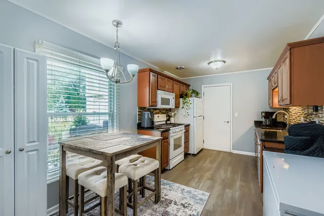 a kitchen with stainless steel appliances granite countertop a stove refrigerator and a wooden cabinets